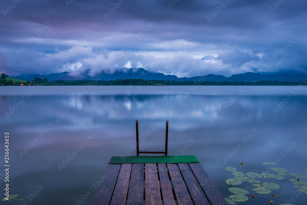 Fototapeta premium See mit Steg am Abend im Sommer - Hopfensee im Allgäu