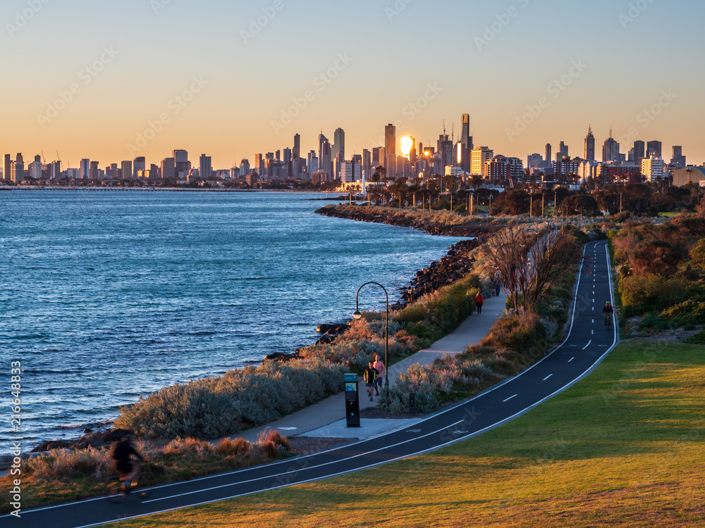 Obraz premium Runners and cyclists enjoying the sunset from Ormond point in Melbourne, Australia