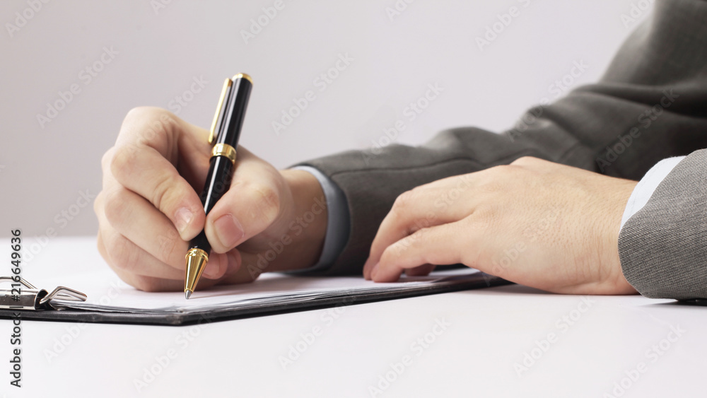 closeup.businessman signing a contract sitting at his Desk closeup.businessman signing a contract sitting at his Desk