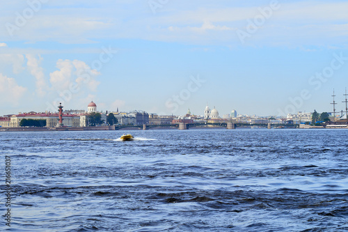 A yellow pleasure boat sails along the canals of the city of St. Petersburg, Russia.