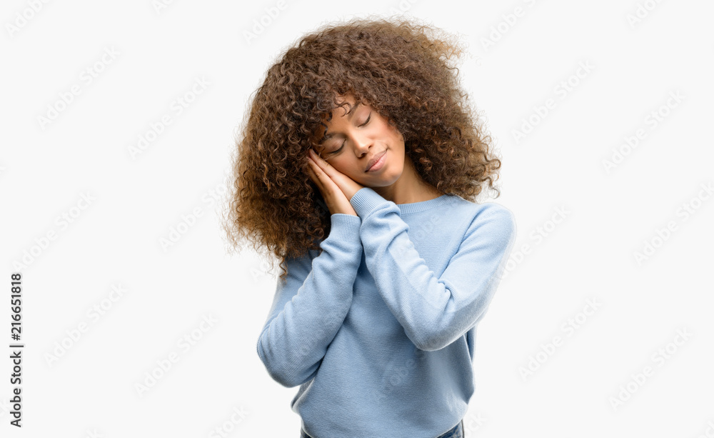 African american woman wearing a sweater sleeping tired dreaming and posing with hands together while smiling with closed eyes. African american woman wearing a sweater sleeping tired dreaming and posing with hands together while smiling with closed eyes.