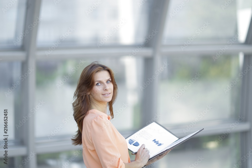 rear view.a young business woman holds a folder with financial documents rear view.a young business woman holds a folder with financial documents