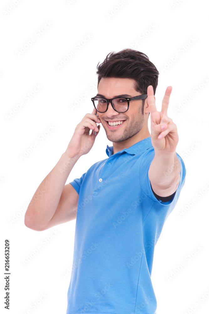 excited man making victory sign while talking on the phone excited man making victory sign while talking on the phone