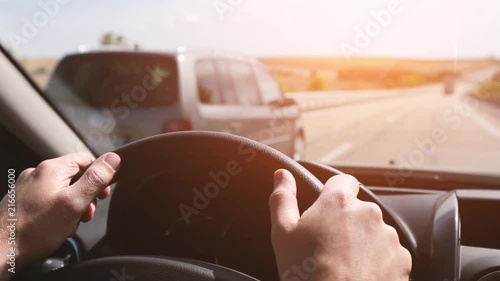driving car on highway, close up of hands on steering wheel in sunny day