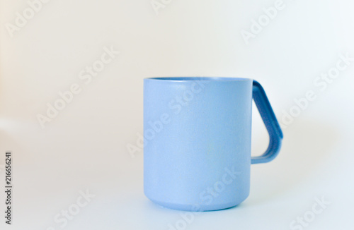 blue plastic mug isolated on white background. selective focus.