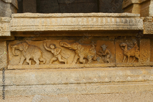 Carved figures on the plinth of the inner courtyard, cloisters or pillared verandah. Achyuta Raya temple, Hampi, Karnataka. Sacred Center. View from the south. photo