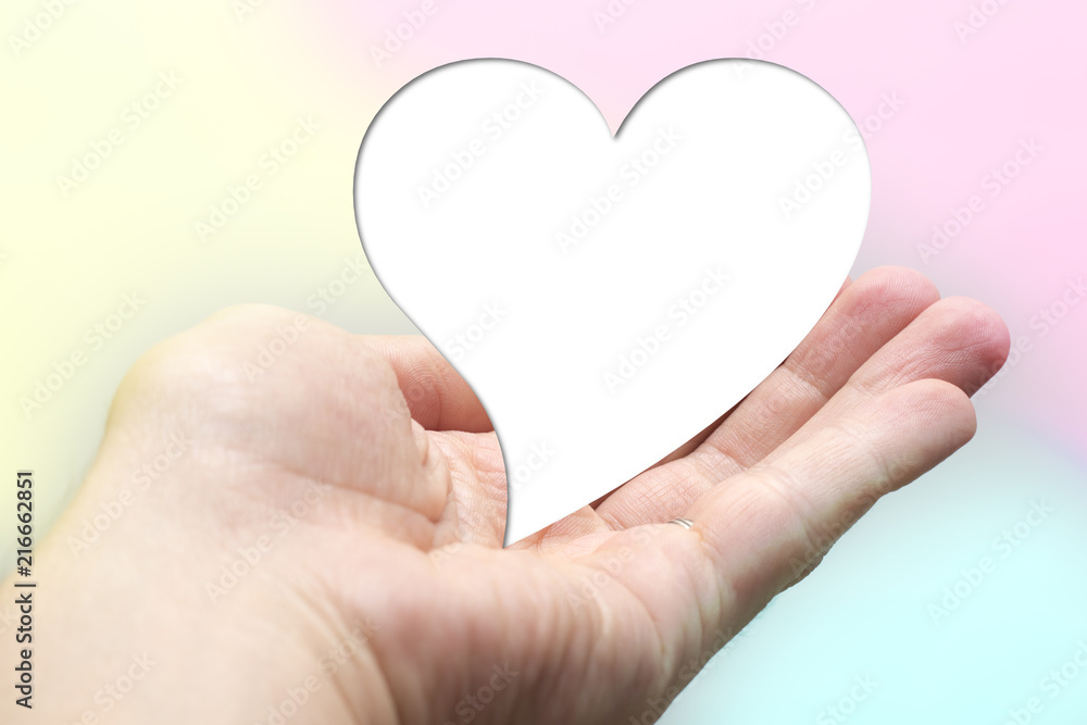 White for text heart shape lay on hand with colorful background. Valentine day. Yellow pink aqua blurred White for text heart shape lay on hand with colorful background. Valentine day. Yellow pink aqua blurred
