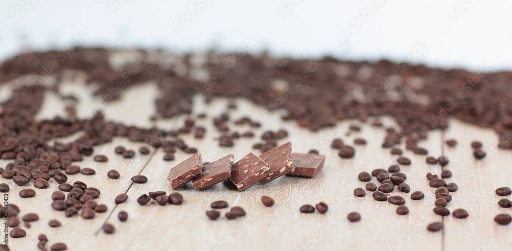 black coffee beans and chocolates on wooden background black coffee beans and chocolates on wooden background