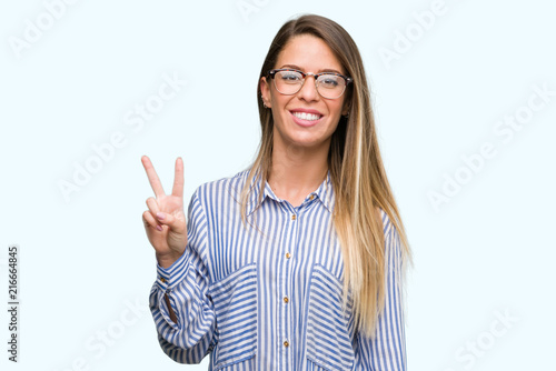 Wallpaper Mural Beautiful young woman wearing elegant shirt and glasses showing and pointing up with fingers number two while smiling confident and happy. Torontodigital.ca