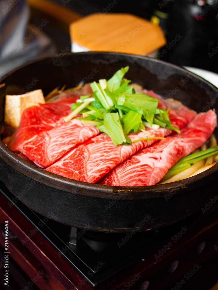 Tasty and delicious Japanese Sukiyaki nabe with best-quality cuts of thinly sliced sirloin or rib eye or tenderloin Kuroge Wagyu beef in a cast iron pan. Top and highest Marble Score. Natural light. Tasty and delicious Japanese Sukiyaki nabe with best-quality cuts of thinly sliced sirloin or rib eye or tenderloin Kuroge Wagyu beef in a cast iron pan. Top and highest Marble Score. Natural light.