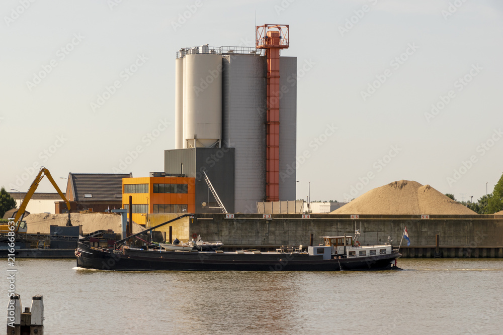 Factory across the river. An inland vessel is passing by. Schoonhoven, The Netherlands.