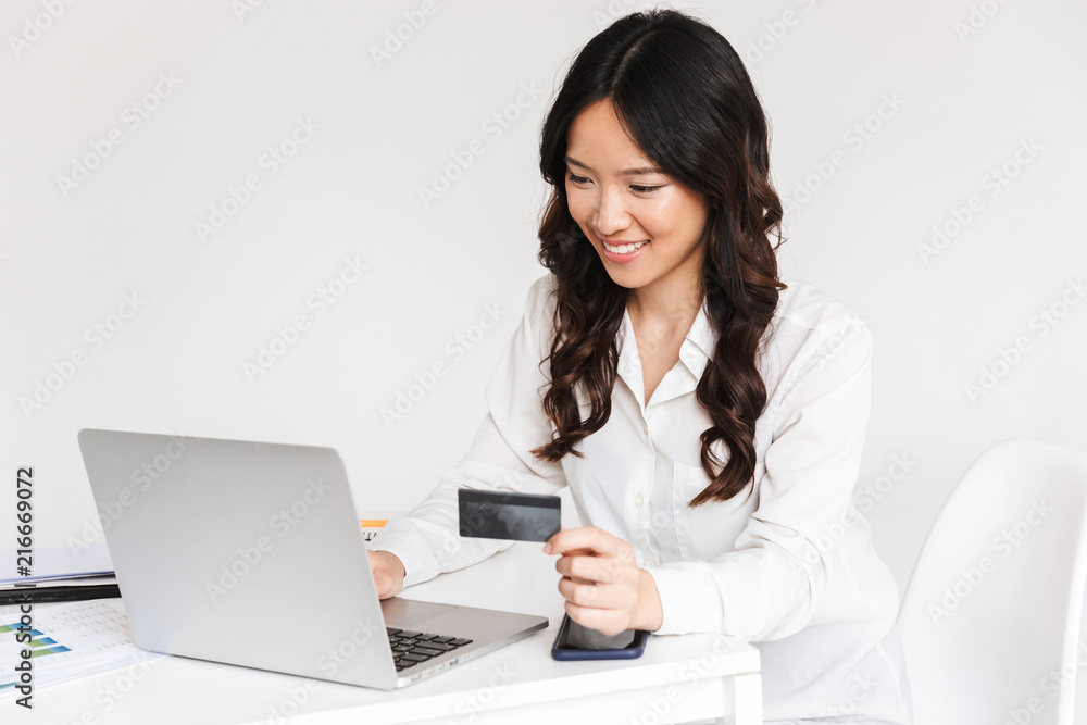 Smiling young asian businesswoman holding plastic credit card Smiling young asian businesswoman holding plastic credit card