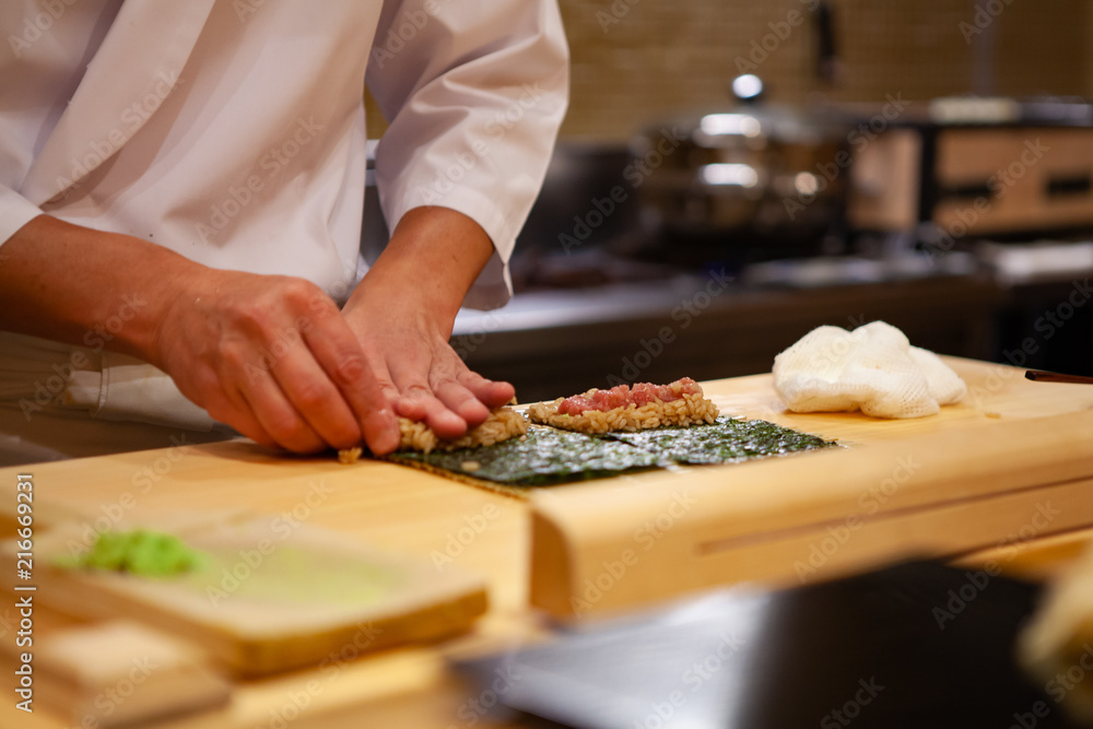 Professional and experienced sushi chef is focus and carefully make sushi with confident and dedication to perfection. Precision and Finesse at its best practice to achieve top performance in business