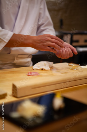 Professional sushi chef carefully using just the right pressure to make perfect sushi with confident and dedication. Precision and Finesse at its best practice to achieve top performance in business.