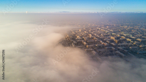Aerial photo of city Magnitogorsk with the looming fog in the winter evening, Low lying cloud over the city
