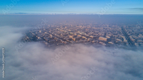 Aerial photo of city Magnitogorsk with the looming fog in the winter evening, Low lying cloud over the city
