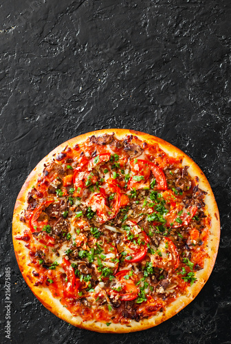 Pizza with Mozzarella cheese, mushrooms, Tomatoes, pepper, Spices and Fresh Basil. Italian pizza. on black background. with copy space. top view