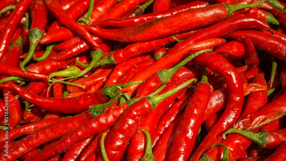 lots of fresh large red spicy chillis shot from overhead at outdoors market in traditional market in indonesia
