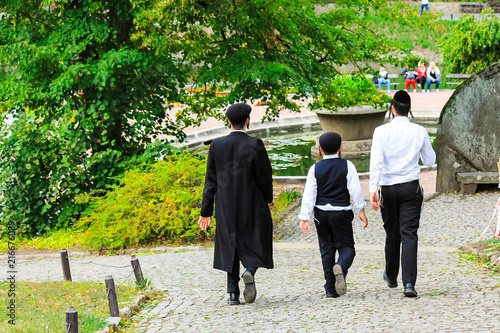 3 boys , a family of Hasidic Jews, in traditional clothes walk in the park in Uman, Ukraine, the time of the Jewish New Year, Religious Orthodox Jew