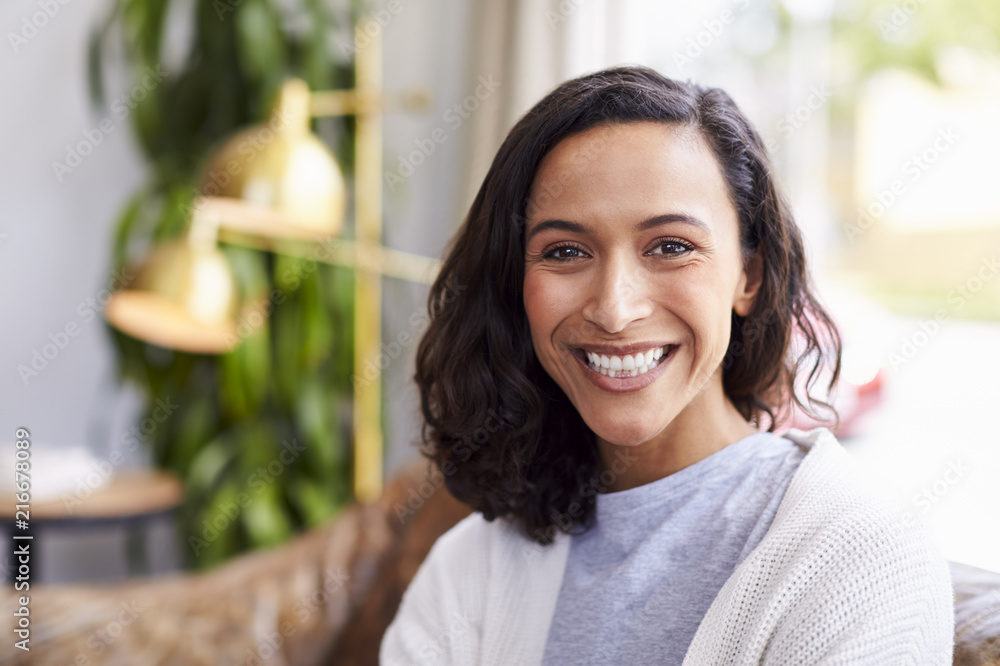 Young mixed race woman in coffee shop smiling to camera
