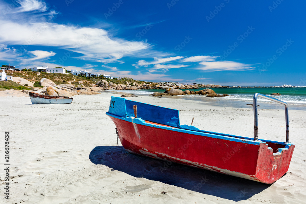 A red fishing boat on the white sand of the beach at Paternoster in South Africa