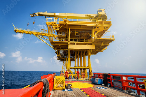 Supply boat or crew boat transfer cargo to oil and gas industry and moving cargo from the boat to the platform, boat waiting transfer cargo and passenger between oil and gas platform