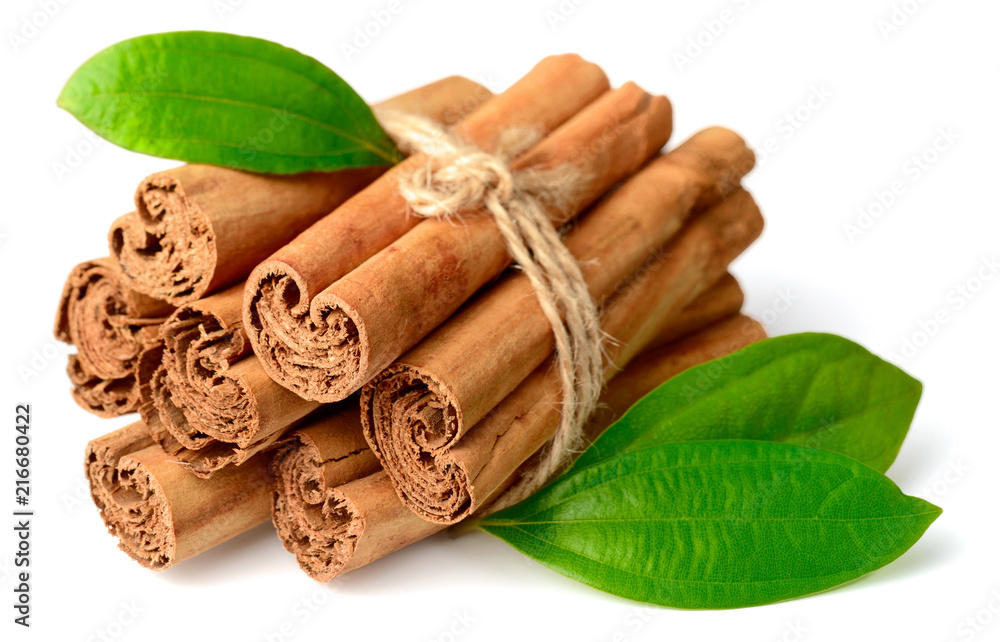 bunch of cinnamon sticks with fresh leaves isolated on the white background - obrazy, fototapety, plakaty 