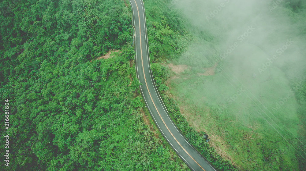 Aerial top view of sky road over top of mountain with fog and green jungle after raining in morning - obrazy, fototapety, plakaty 