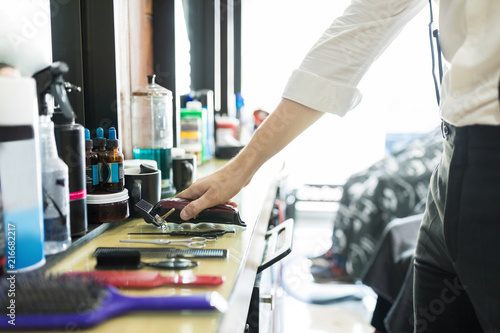Hair Expert Keeping Trimmer On Counter In Salon