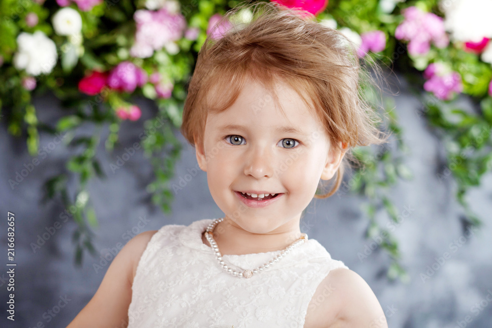 Portrait of the lovely little girl with flowers. Looking at camera Portrait of the lovely little girl with flowers. Looking at camera