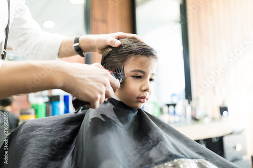 Boy Having His Hair Trimmed In Barber Shop