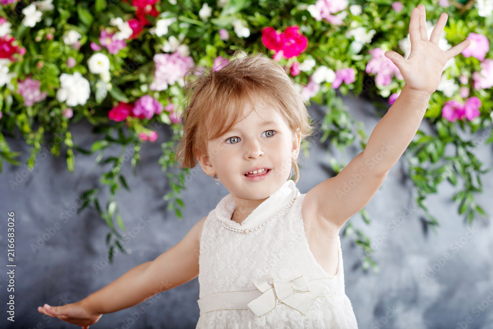 Portrait of the lovely little girl with flowers. The girl laughs and plays Portrait of the lovely little girl with flowers. The girl laughs and plays