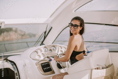 Young attractive woman drives a  yacht at sea © BGStock72