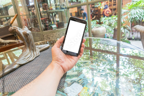 close up smartphone in coffee shop with on white on screen background.