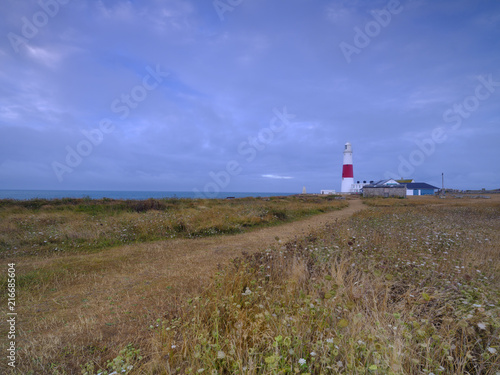 Summer sunrise with stormy clouds and slow shutter speed at Portland Bill Light  Dorset  UK