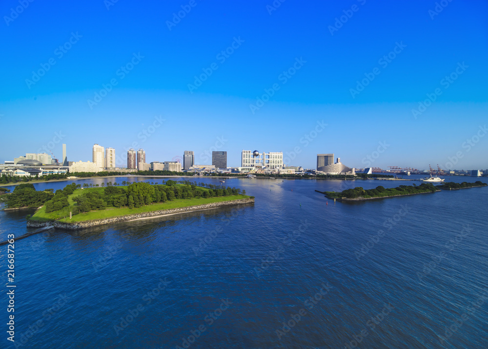 View of the bay of Odaiba with daiba park and the beach in the distance.