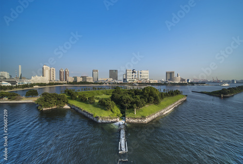 View of the bay of Odaiba with daiba park and the beach in the distance. photo