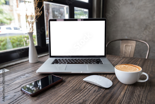 blank screen laptop computer with mouse and smart phone on wooden table, dark background