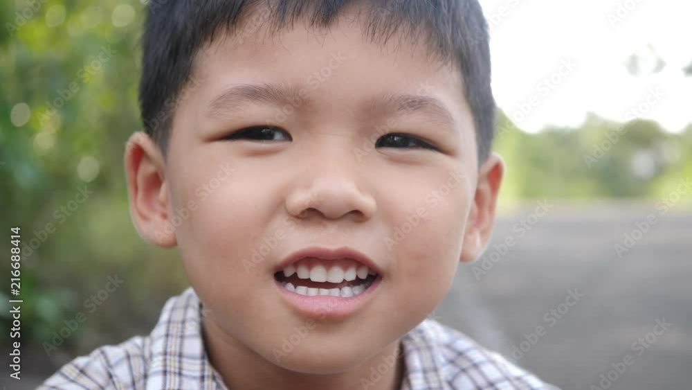 Close up little boy laughing and smile after hearing joke story Close up little boy laughing and smile after hearing joke story