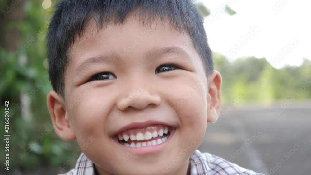 Close up little boy laughing and smile after hearing joke story Close up little boy laughing and smile after hearing joke story