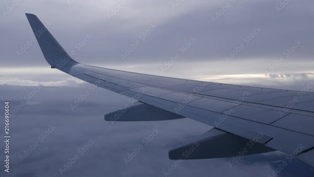 View from airplane with wing flying in the sky between layers of clouds. View from airplane with wing flying in the sky between layers of clouds.