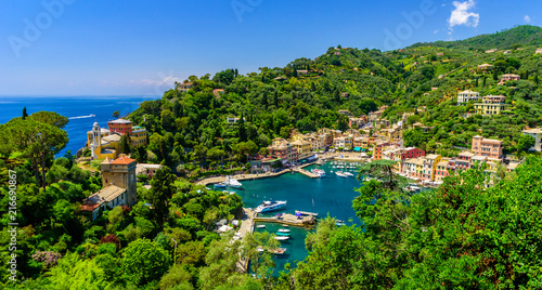 Portofino, Italy - colorful houses and yacht in little bay harbor. Liguria, Genoa province, Italy. Italian fishing village with beautiful sea coast landscape in summer season.