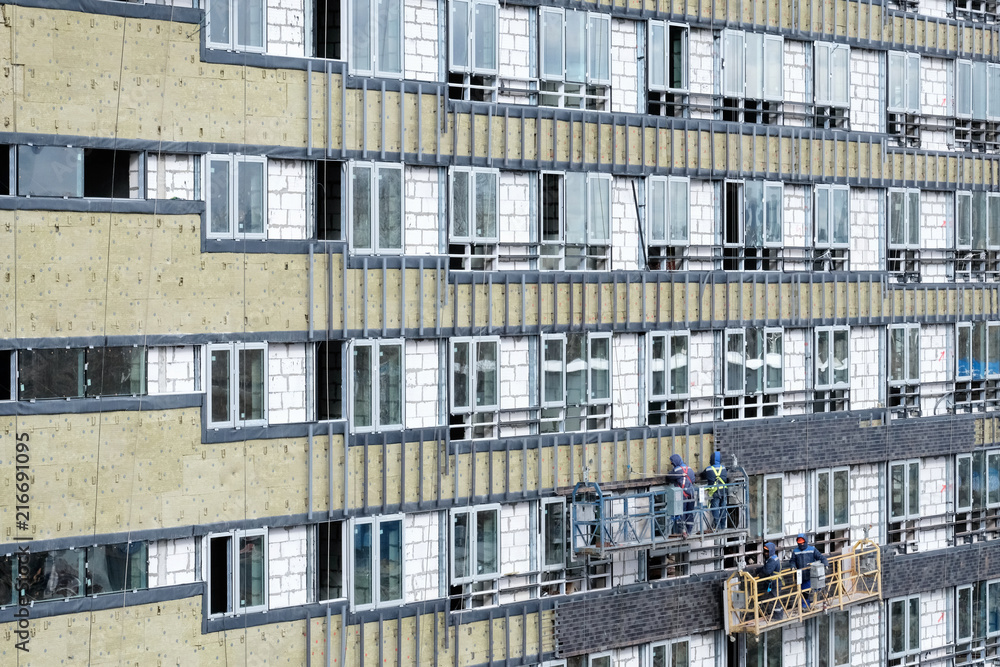 Obraz premium New building construction site with scaffolding and workers