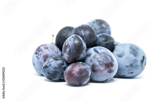 heap of ripe delicious plums on white background