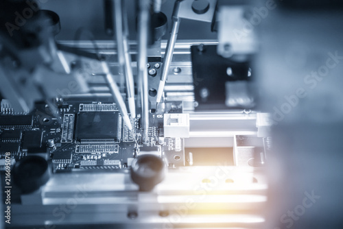 The assembly line of electronic board with microchip in the light blue scene.The electronics board production process.