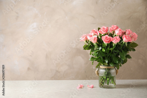 Vase with beautiful rose flowers on table