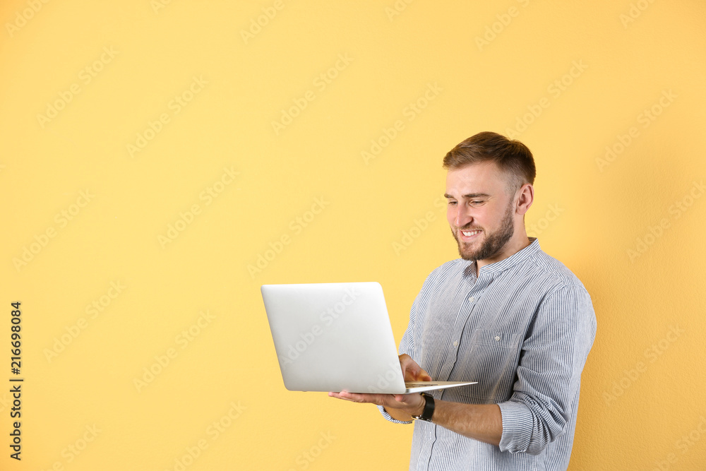 Young man with laptop on color background Young man with laptop on color background