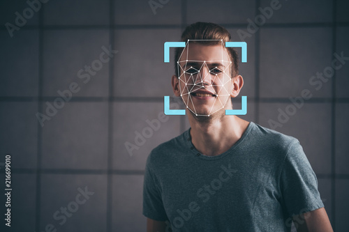 Face recognition. Biometric verification. The concept of a new technology for face recognition on a polygonal mesh. A young guy with a polygonal mesh on his face.
