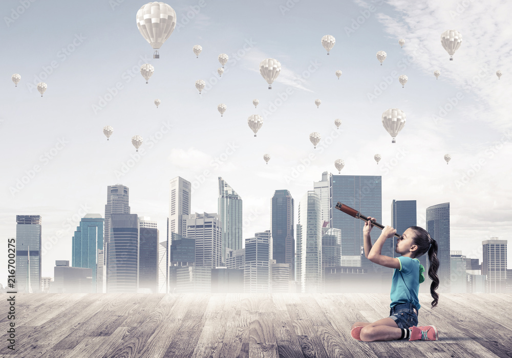 Φωτογραφία Concept of careless happy childhood with girl looking in spyglas
