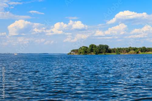 Summer landscape with beautiful lake, green trees and blue sky